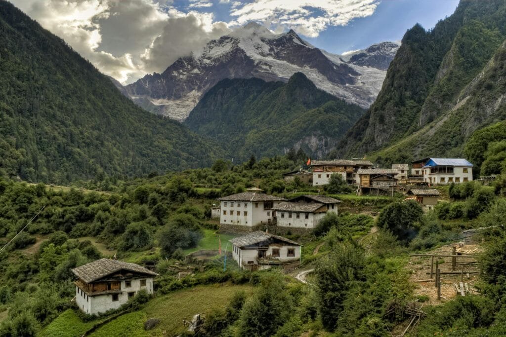 Picturesque village nestled in the Himalayas with lush greenery and towering mountains.