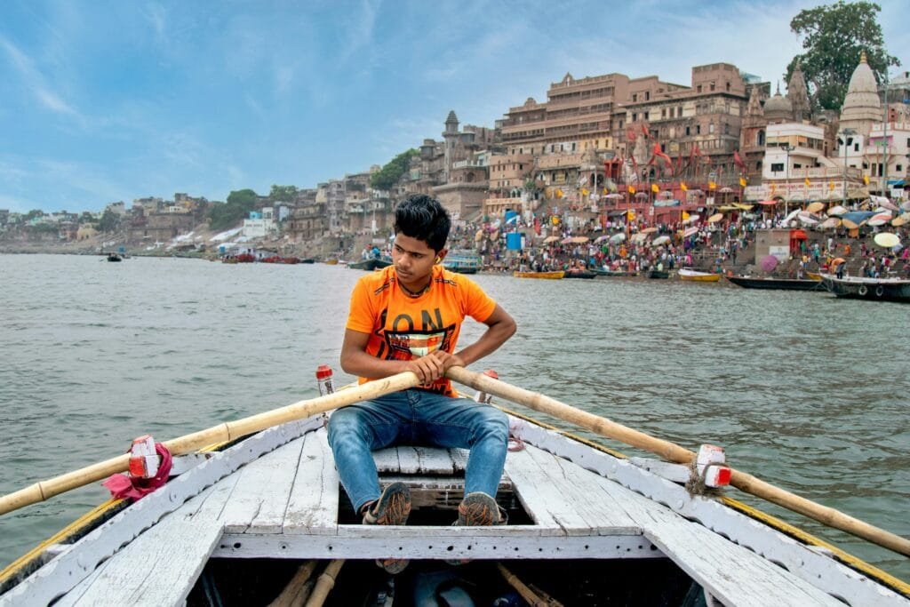 Young Man on a Boat Rowing Down the Ganges in Varanasi